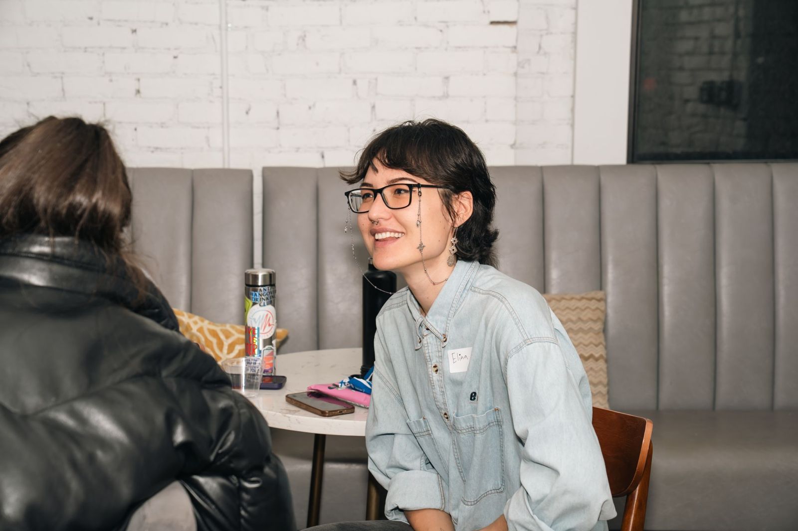 Elina reading poetry at a Storyo event in front of an Auckland mural